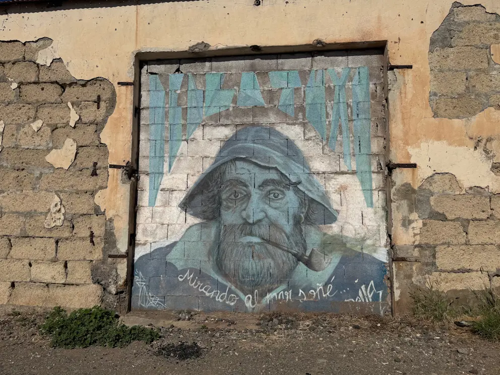 Mural przedstawiający rybaka z fajką i napis "Mirando el mar soñé..."