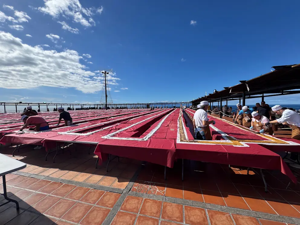 Panorama stołów z turrónem rozłożonych na placu w Puerto de Santiago, w tle ocean