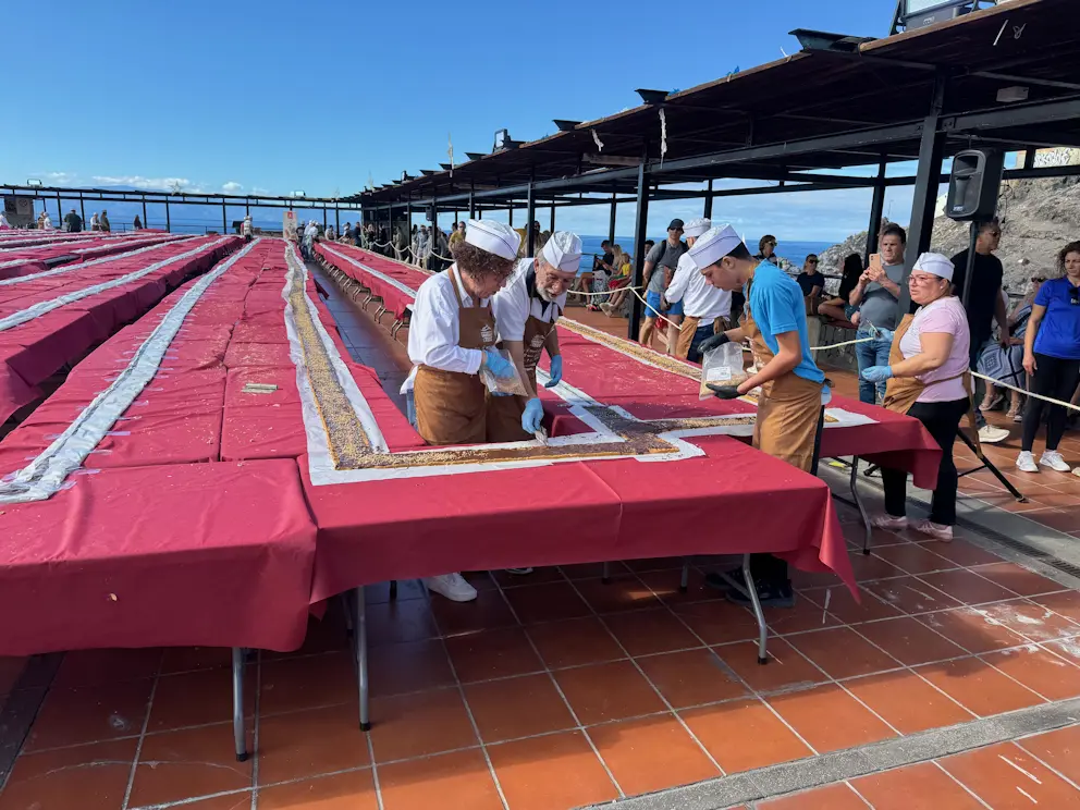 Cukiernicy pracujący przy turrónie, obserwowani przez publiczność